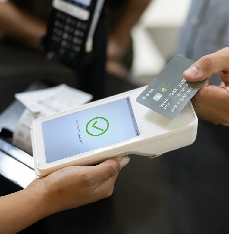 A person using a tap to pay handheld credit card reader