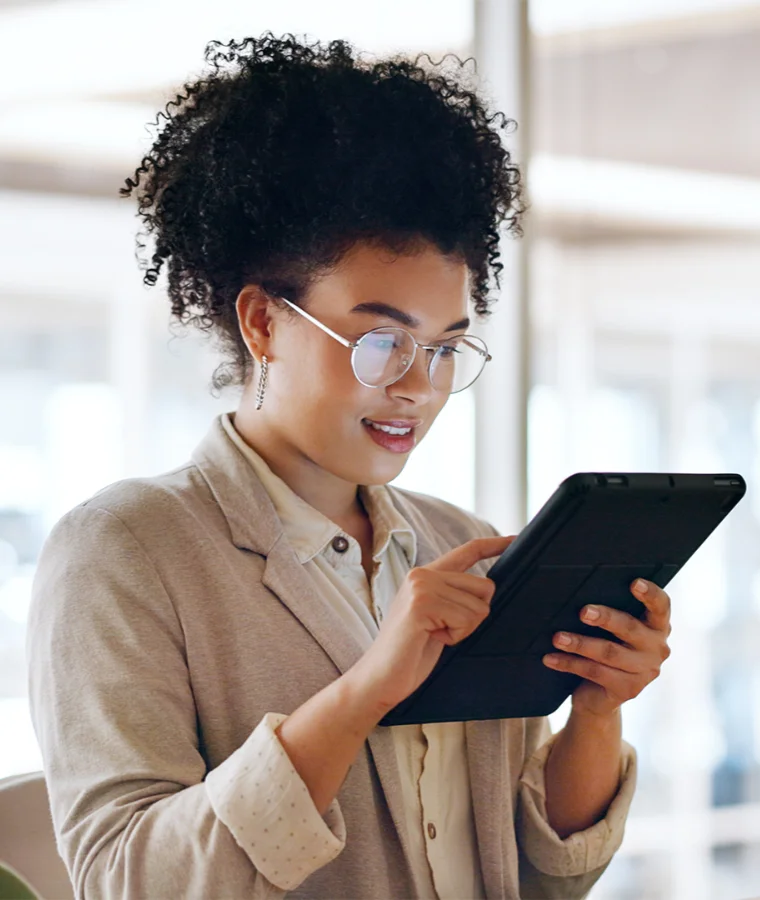 A smiling woman using a tablet compputer