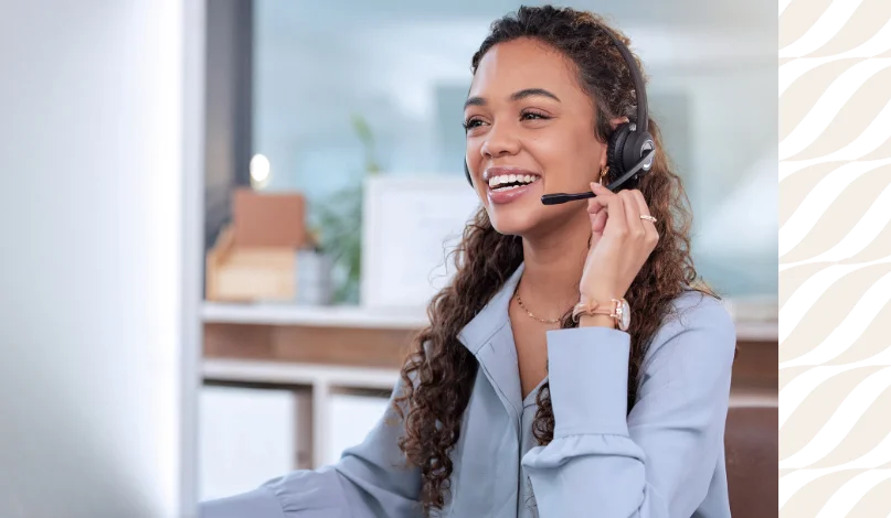 a smiling woman talking on a headset